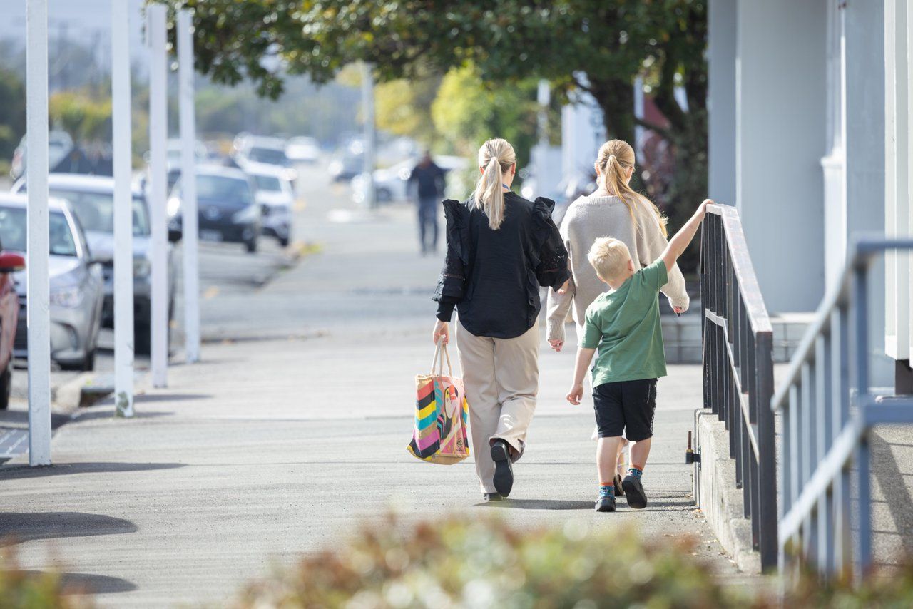 A family walking along a Westport footpath in the sun.